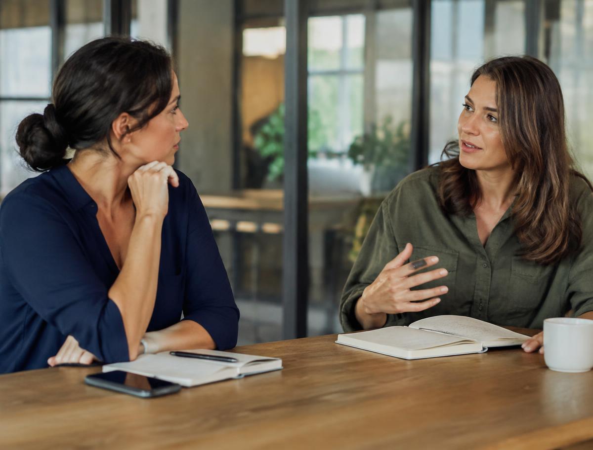Two professionals in a reflective one-on-one coaching conversation